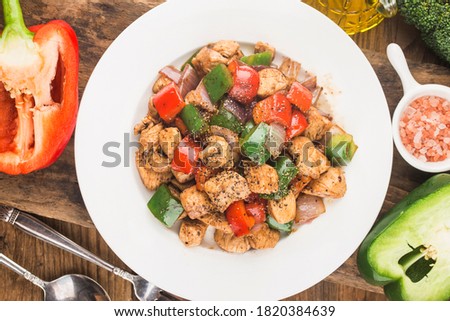 A plate of fried chicken breast with colored pepper