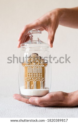 Gingerbread house in glass jar. Concept- sale, purchase house, cozy home, safe property, mortgage, credit, apartment renovation. Stay home, quarantine