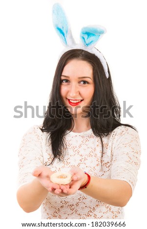 Happy woman with bunny ears holding little egg in nest in her palms isolated on white background
