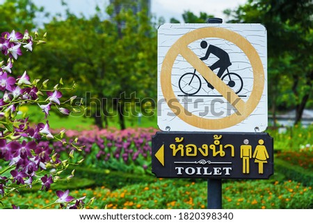 A sign forbidding bicycles and giving directions to the toilet
