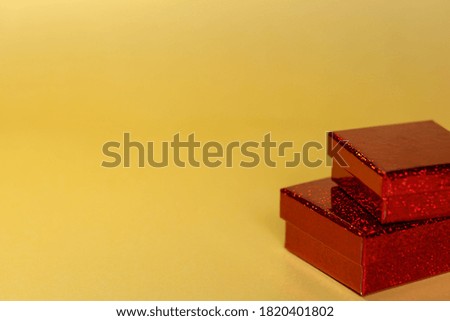 Two red gift boxes for the holiday on a yellow background. Text space