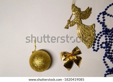 New Year's picture. Gold angel, gold ball, gold bow and blue beads. Copy space for text.