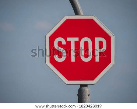 Traffic sign, stop sign, on an iron bracket against a blue sky