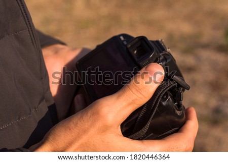 Hand of a man holding professional digital camera 