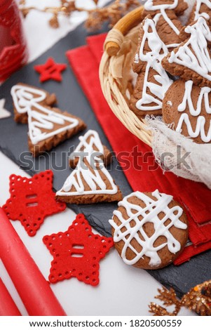 Christmas gingerbread. Homemade cakes: Christmas tree cookies. Cookies with decor. Gingerbread cookies on a red and black background.