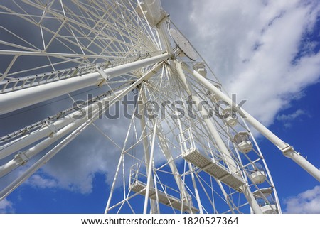 Large ferris wheel attraction shot against a cloudy sky