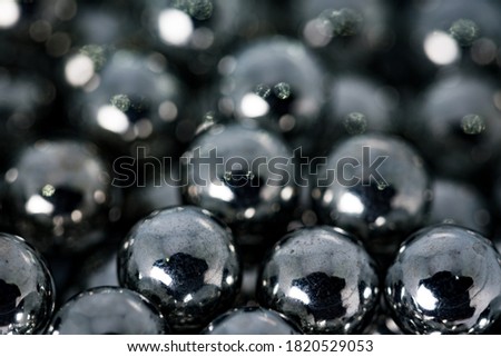 Metal balls with shiny reflections. The balls are arranged next to each other, the structure is made of many elements. Slingshot bullets, ball bearings.