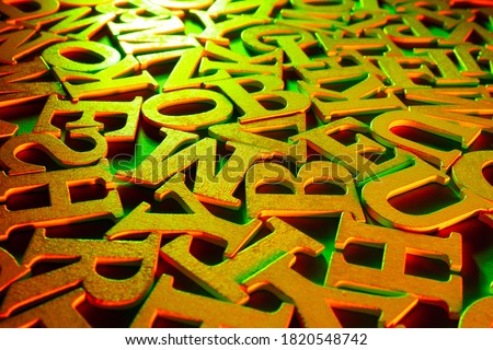 Golden alphabet letters. Volumetric gilded letters. Alphabet is in a chaotic state. Letters as a symbol of reading. Reading English literature. Reading training. Concept - writing and selling books