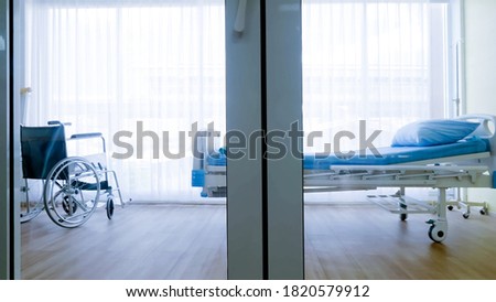Bedroom for patient in a hospital, Empty bed and wheelchair on hospital ward.