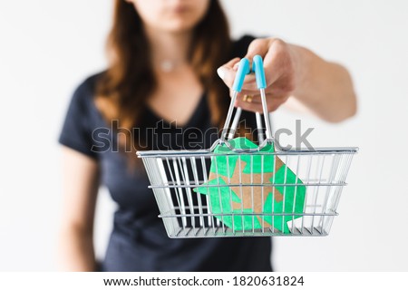 sustainable development and consumer buying habits concept, woman holding a shopping basket with recycle sign towards the camera shot at shallow depth of field Royalty-Free Stock Photo #1820631824