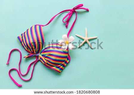 Summer items and accessories  traveler woman colorful bikini with flower frangipani to travel plan holiday vacation in the beach. Tropical sea. Unusual top view, Travel and Summertime Concept.
