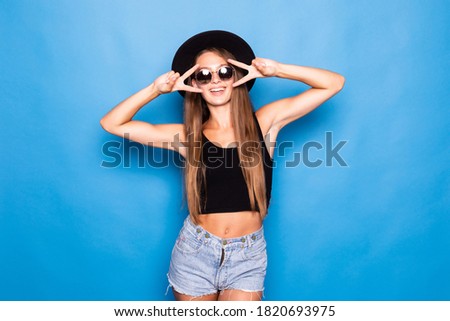 Young pretty woman showing peace gesture standing isolated over blue background.