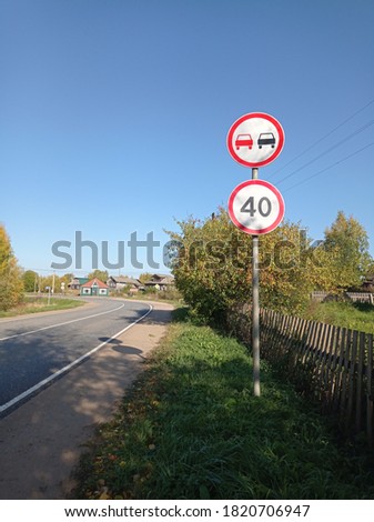 speed limit road sign and no overtaking on blue sky background
