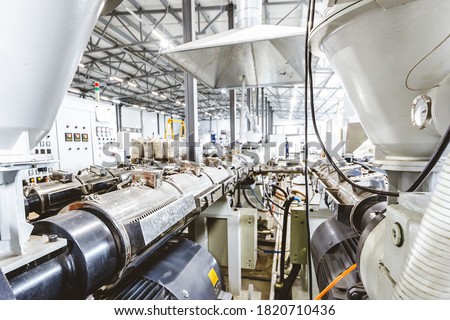 Workshop with extruders for producing plastic pipes. High speed extrusion line of water suppply and gas pipe. Manufacturing facility. Royalty-Free Stock Photo #1820710436