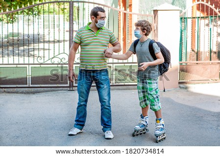 Sad child and father walk in protective masks holding hands on roller skates. Dad takes his son from the playground. Schoolboy teenager returns from school. Activities in quarantine coronavirus covid
