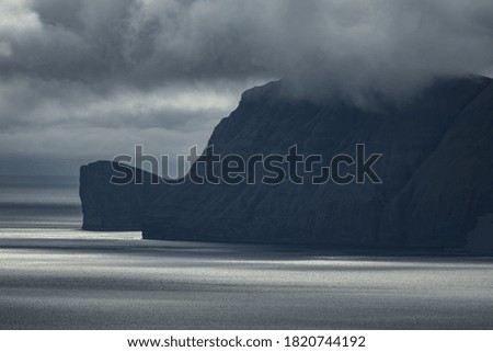 Extreme coastline silhouette of Faroe Islands under stormy the clouds