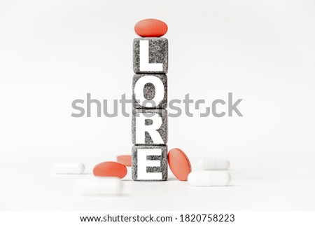 a group of white and red pills and cubes with the word LORE on them, white background. Concept carehealth, treatment, therapy.