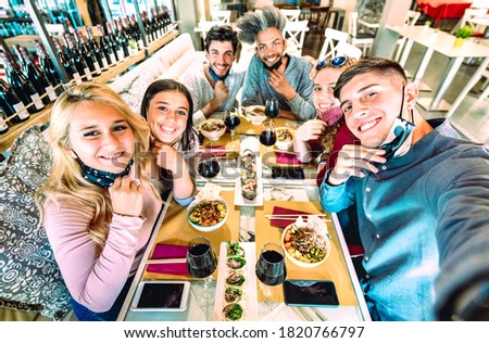 Friends taking selfie at sushi bar restaurant - New normal lifestyle concept about young people having fun together at fashion diner with open face masks - Bright saturated filter - Focus on right guy Royalty-Free Stock Photo #1820766797