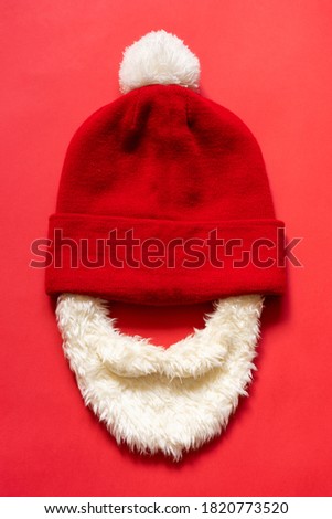 Santa hat with a beard on a red background. Christmas concept.