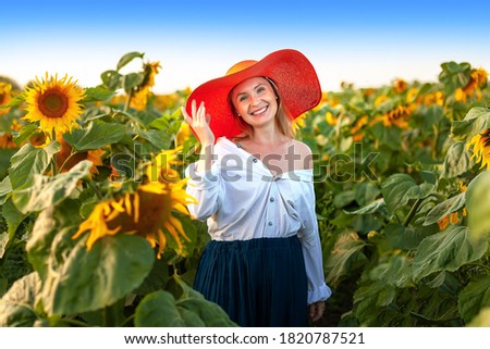 Beautiful woman in hat in a field of sunflowers