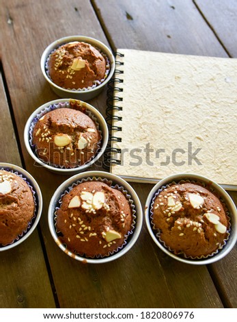 Picture of ready-to-eat banana cake with eggs, brown, sprinkled with white sesame, served in a plate with note paper.