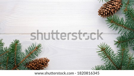Christmas fir tree with pinecones on a white wooden board and copy space for your text. Banner.Flat lay