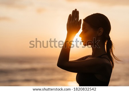Yoga at sunset on the beach. woman performing asanas and enjoying life on the ocean. Bali Indonesia. Royalty-Free Stock Photo #1820832542