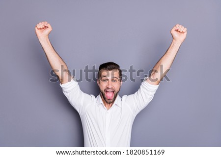Portrait of his he nice attractive successful excited cheerful cheery man having fun celebrating match cup goal sport game isolated over grey violet purple pastel color background
