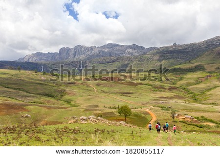 Group of kids from school walking in the amazing landscape of two legendary waterfalls "King and Queen" in Andringitra National Park in Madagascar  and near Namoly valley