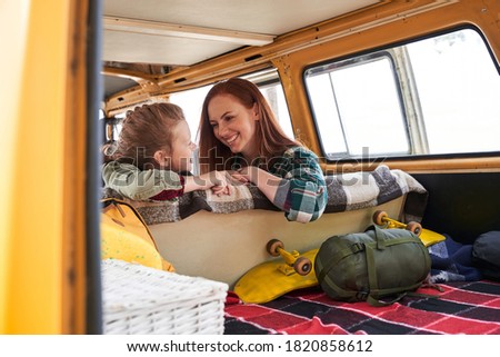 Beaming redhead charming mom and interested kid talking with each other at the car among the woods. Happy parent having leisure with child outdoor concept