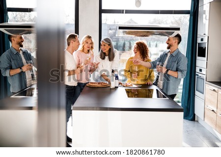 Funny people standing with glasses of wine and chatting on interesting stories stock photo