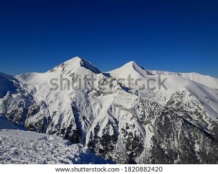 Beautiful winter landscape. Snow on the mountain with blue sky background. Mount Carpathians in the Bansko region of Bulgaria. Todorka Peak with a height of 2746 m (9009 ft.), above sea level.