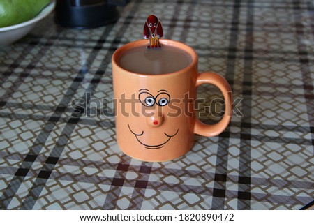 Mug of coffee with smile face on the table