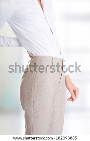 Woman with back pain holding her aching hip 