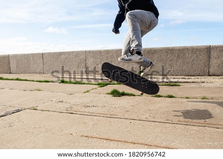 closeup of a young man performing a trick with his skate in the sunny street