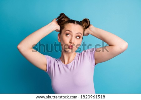 Photo of attractive teen lady touch check nice hairstyle two funny pretty buns hairdo like new style look flirty empty space send kisses wear casual t-shirt isolated blue color background