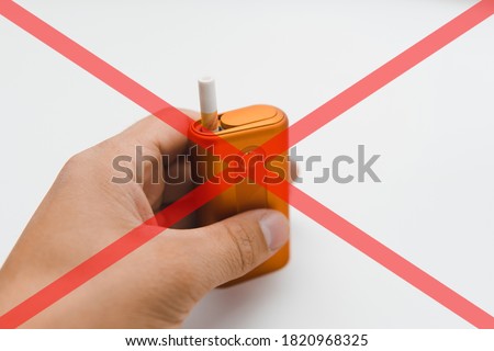 Heat-not-burn product with a stick on white background with red cross. Smoking ban concept.