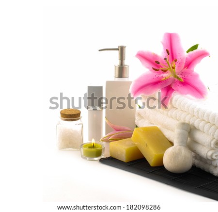 Spa setting with pink lily, massage oil, ball, soap, towel ,mat 