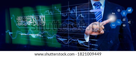 Businessman touching data analytics process system with KPI financial charts, dashboard of stock and marketing on virtual interface. With Saudi Arabia flag in background.