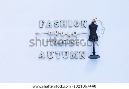 Autumn Fashion Trend Style – Horizontal Text on the Middle with Earing Face Doodle Decoration and Mannequin Symbol - on Wooden White Background. Creative Elegant Composition Flat Lay, Invitation, Card