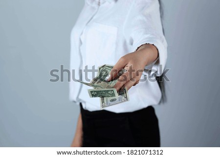 young woman hand money on grey background