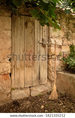 Old broom next to the door of an old corral or farmhouse Royalty-Free Stock Photo #1821105212