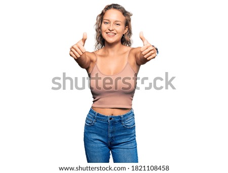 Beautiful caucasian woman wearing casual clothes approving doing positive gesture with hand, thumbs up smiling and happy for success. winner gesture. 