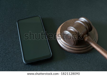 Smartphone and judges gavel on black background. Crime. Template. Mockup.