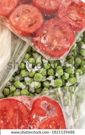 Set of frozen food packed in bags. Store vegetables for the winter, top view. Tomato, green peas.