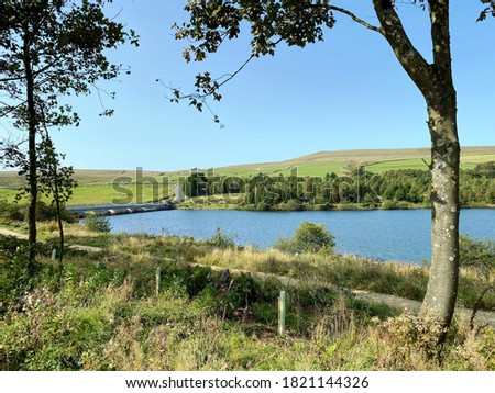 Looking across, Baitings Reservoir, with old trees, and a farm in the distance near, Ripponden, Sowerby Bridge, UK