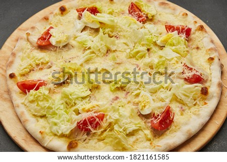 Delicious Italian pizza Caesar on dark background
