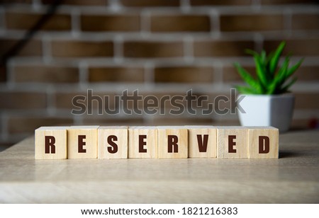 Reserved word wooden cubes on pink background