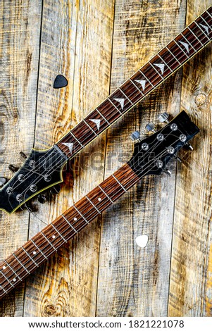 Two electric guitar bodies on wooden board background.