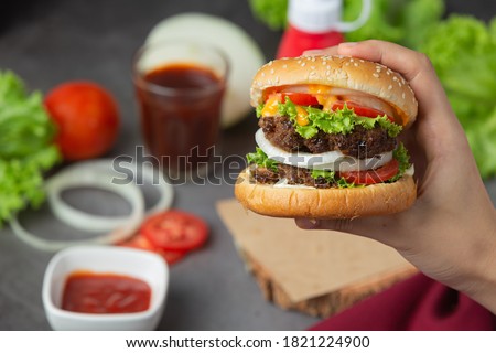 Hamburger with fried meat, tomatoes, pickles, lettuce and cheese World Food Day.